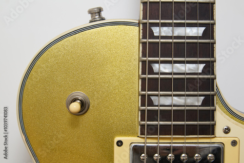 Close-up photograph of a vintage gold-plated electric guitar, details