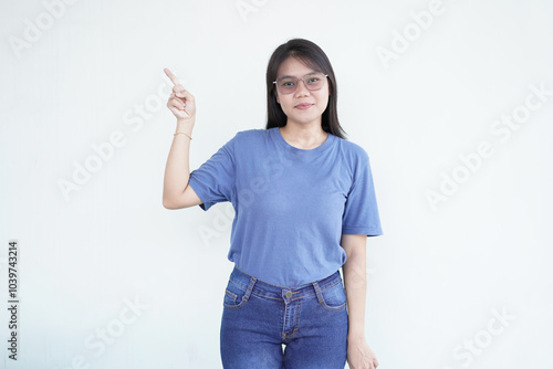 Beautiful Asian woman smiles while pointing to the side copy space, perfect for advertising or promotions on a white background