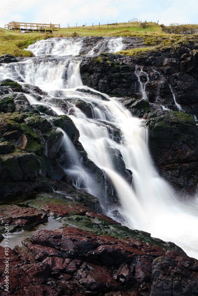 Crystal clear water flows down the waterfall at Dunseverick on the Causeway Coast of Northern Ireland, an area of unspoiled and outstanding natural beauty. Crystal clear water flows down the waterfall at Dunseverick on the Causeway Coast of Northern Ireland, an area of unspoiled and outstanding natural beauty.