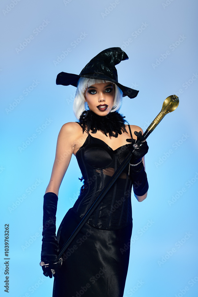 Dressed in a stunning witch costume, a young woman confidently poses with a stylish wand. Dressed in a stunning witch costume, a young woman confidently poses with a stylish wand.