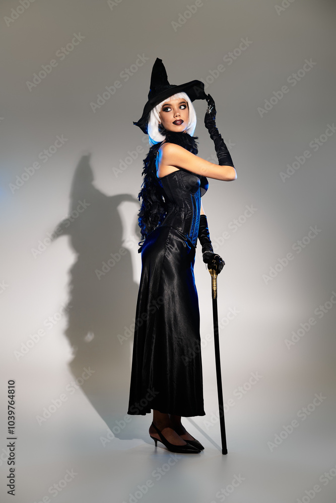 A beautiful young woman poses in an elegant witch costume, ready for Halloween festivities. A beautiful young woman poses in an elegant witch costume, ready for Halloween festivities.