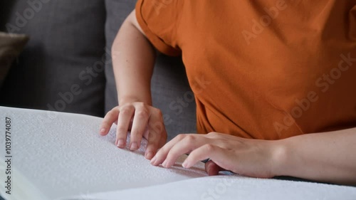 Wallpaper Mural Close-up tilt down view of focused visually impaired young woman reading book with braille dot system while relaxing at home Torontodigital.ca