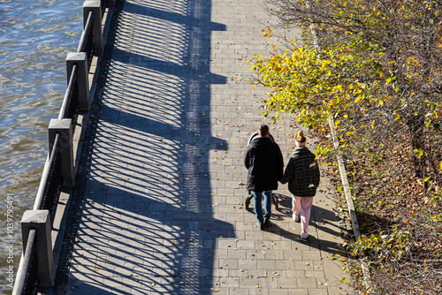 Canvas Print Couple with baby pram walking on river embankment at autumn city park, aerial vi