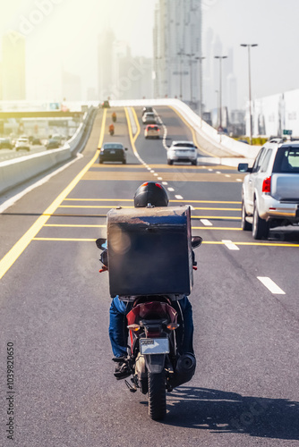 Dubai. Man on a motorcycle for online delivery. Food delivery. UAE. vertical