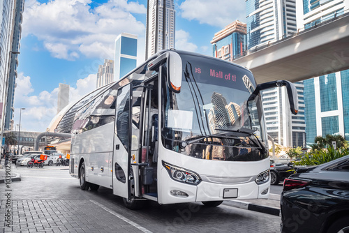 Photography Dubai, UAE. White tourist bus on a city street.