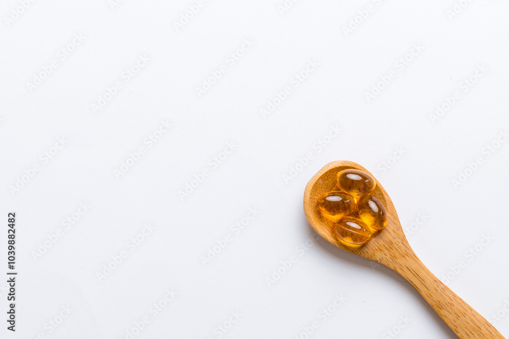Vitamin omega capsules in a spoon on a colored background. Pills served as a healthy meal. Red soft gel vitamin supplement capsules on spoon Vitamin omega capsules in a spoon on a colored background. Pills served as a healthy meal. Red soft gel vitamin supplement capsules on spoon