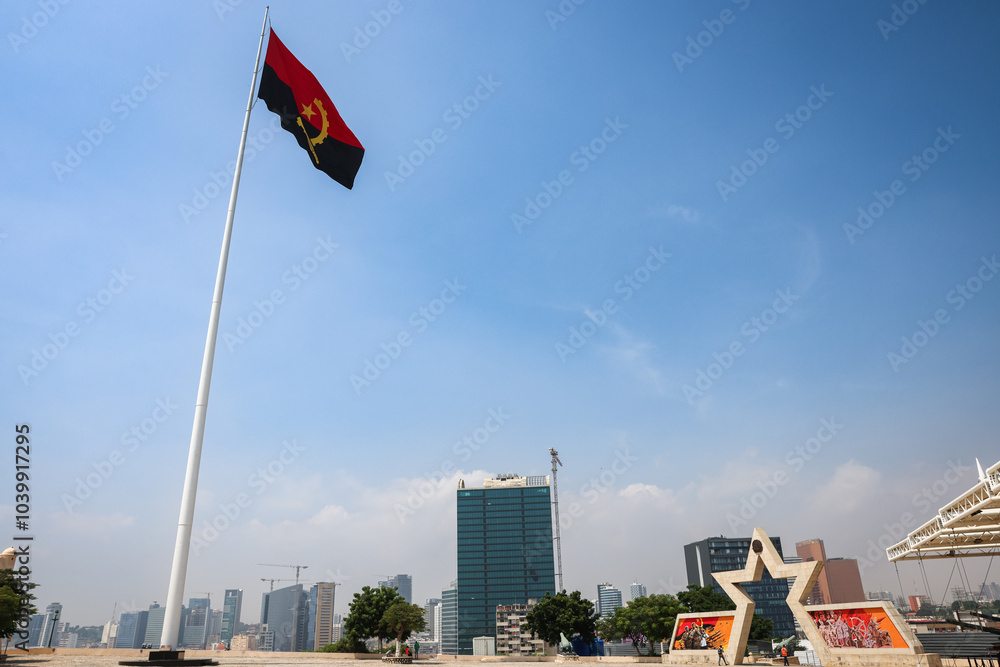 Fototapeta premium A view of Fort San Miguel in Luanda showcasing the Angolan flag and city skyline under a clear blue sky