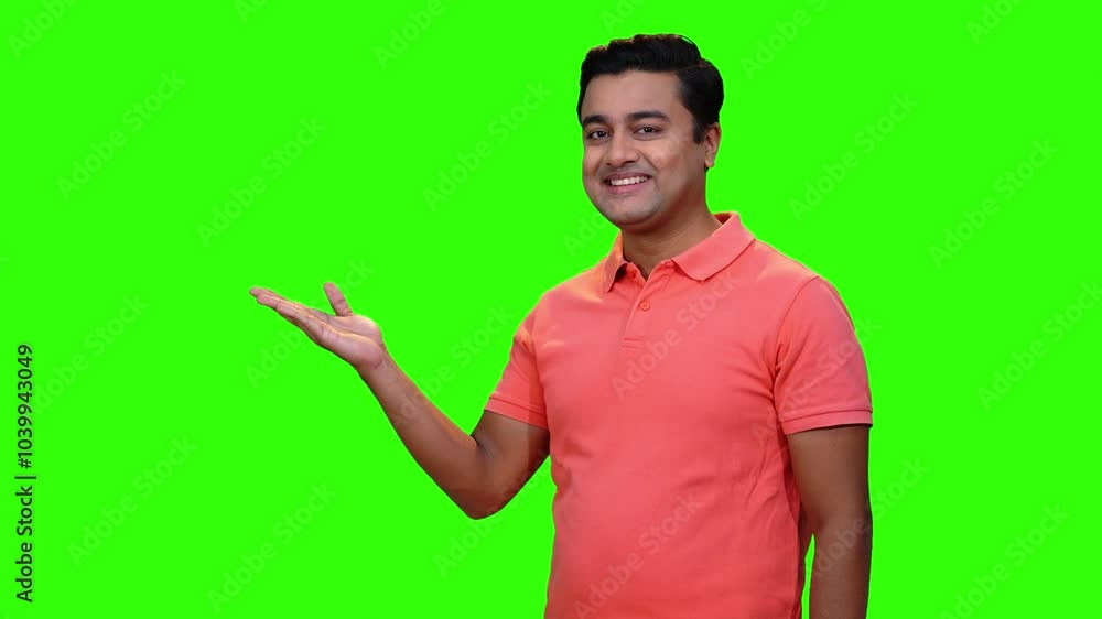A young male model is presenting and displaying something with gestures. Green screen and chroma key compositing. A young male model is presenting and displaying something with gestures. Green screen and chroma key compositing.