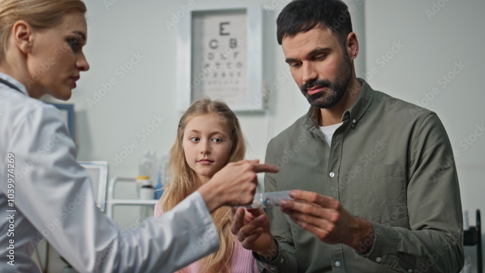 Fototapeta premium Child doctor discussing prescription during appointment. Closeup father visiting
