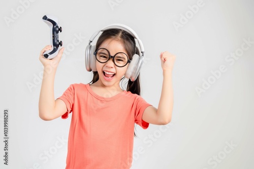 Asian happy portrait young kid girl smile lifestyle games technology holding joystick game playing on hands studio shot isolated white background with copy space.