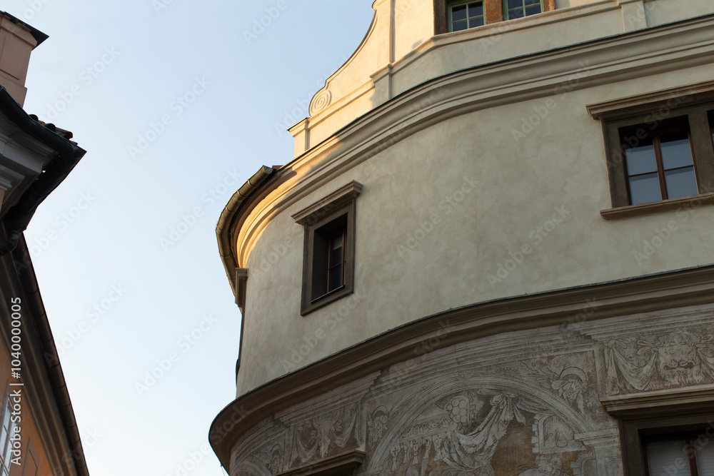 Fototapeta premium A breathtaking and stunningly curved building facade adorned with intricate murals and bathed in warm light