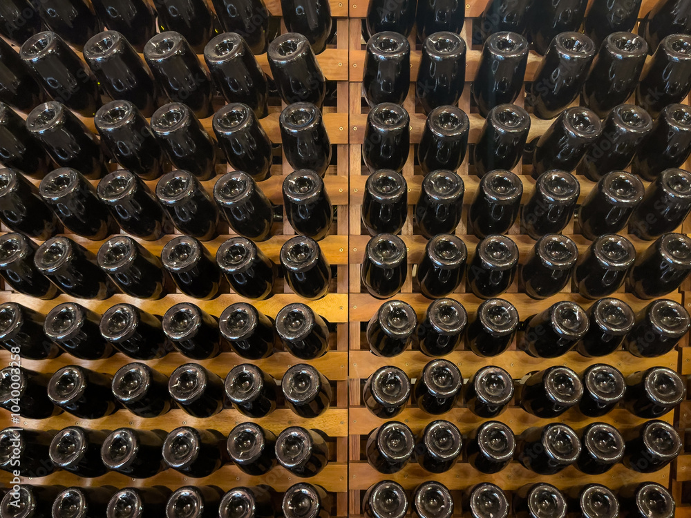 Wine bottles stored upside down in a wooden cellar for aging and preservation. Wine bottles stored upside down in a wooden cellar for aging and preservation.