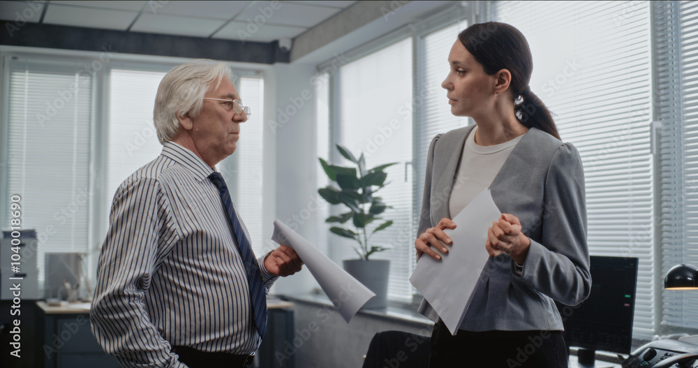 Teamwork in modern office: Senior team leader and female employee have discussion. Two marketing professionals discuss business strategy, brainstorm project ideas. International finance corporation. Teamwork in modern office: Senior team leader and female employee have discussion. Two marketing professionals discuss business strategy, brainstorm project ideas. International finance corporation.