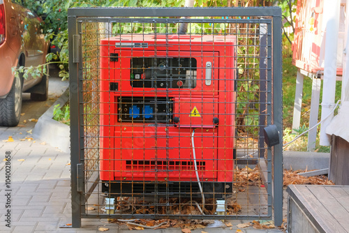 Outdoor diesel power generator. Power supply generator placed on street sidewalk. Small business generators in autumn. Sunny day. photo