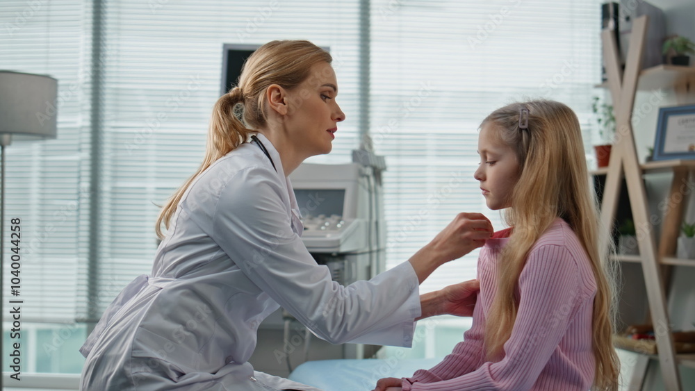 Obraz premium Healthcare worker checking kid health in examination room. Worried woman doctor
