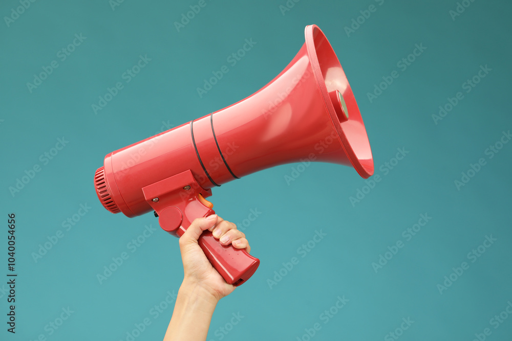 © New Africa - Woman holding megaphone speaker on blue background, closeup
