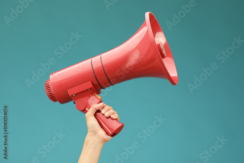 Foto Woman holding megaphone speaker on blue background, closeup
