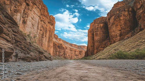 African canyon with a dry riverbed running through it, leaving space for text in the sky.