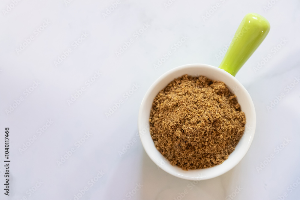 A close-up of brown sugar in a white ceramic bowl on a marble surface, highlighting its texture and natural sweetness. A close-up of brown sugar in a white ceramic bowl on a marble surface, highlighting its texture and natural sweetness.