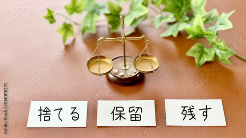 Foto 天秤と3枚のカードに捨てる保留残すの文字_茶色背景