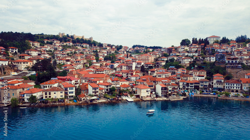 A picturesque view of Ohrid Macedonia showcasing charming houses along the tranquil waters of Lake Ohrid during a cloudy day A picturesque view of Ohrid Macedonia showcasing charming houses along the tranquil waters of Lake Ohrid during a cloudy day