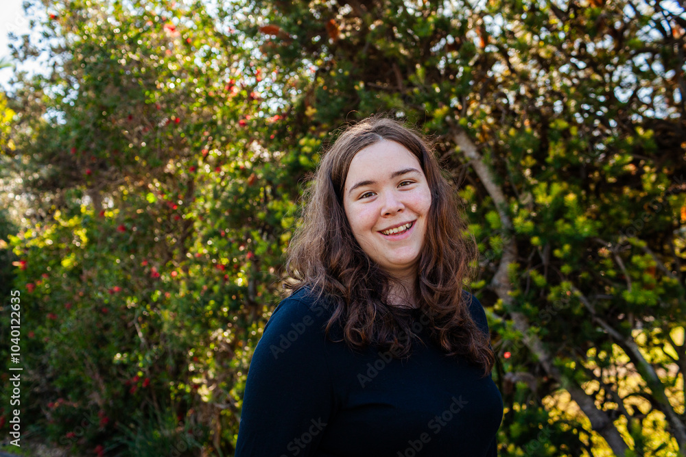 Portrait of happy Australian teenager with backdrop of native bottle brush trees Portrait of happy Australian teenager with backdrop of native bottle brush trees