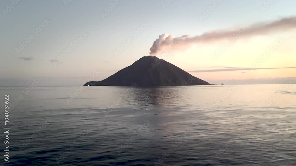 The volcanic island of Stromboli at sunrise with amazing clouds in the sky The volcanic island of Stromboli at sunrise with amazing clouds in the sky