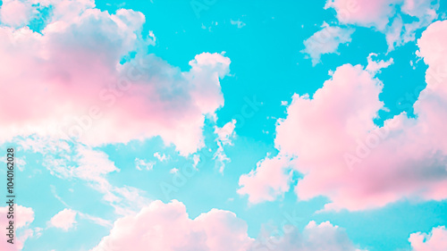 Dreamy pink clouds drifting across bright blue sky for your background. Serene cotton candy clouds under clear turquoise sky.