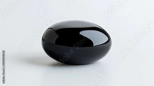 A polished black onyx gemstone, its smooth surface reflecting light on a minimalist white background