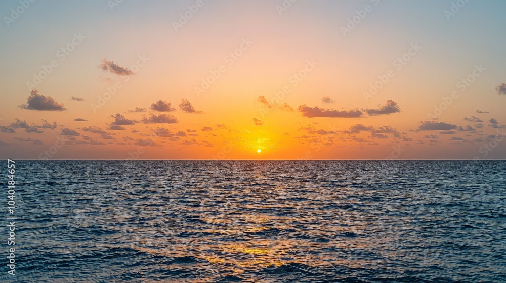 A vibrant orange and pink sunset over the ocean with light clouds. A vibrant orange and pink sunset over the ocean with light clouds.