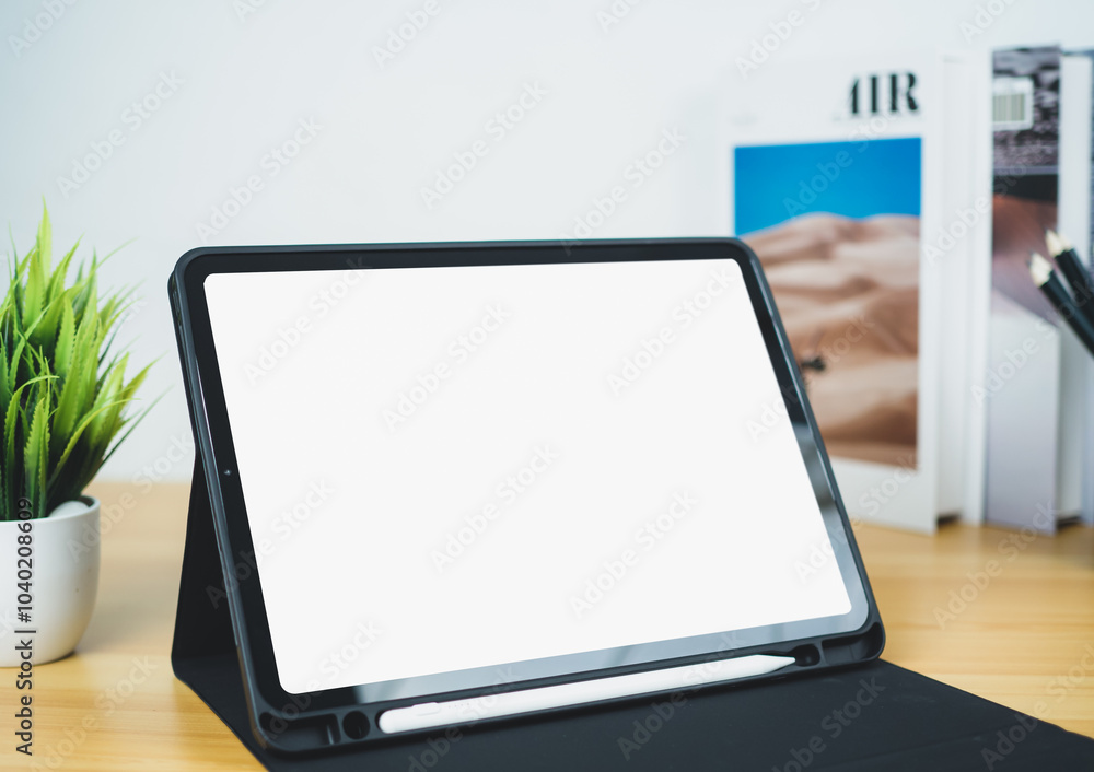 Tablet with blank screen on wooden table. Office supplies, Books, Indoor plants, on wooden table and white wall. Space for copying your text, Workspace and copy space, Desk with office supplies. Tablet with blank screen on wooden table. Office supplies, Books, Indoor plants, on wooden table and white wall. Space for copying your text, Workspace and copy space, Desk with office supplies.