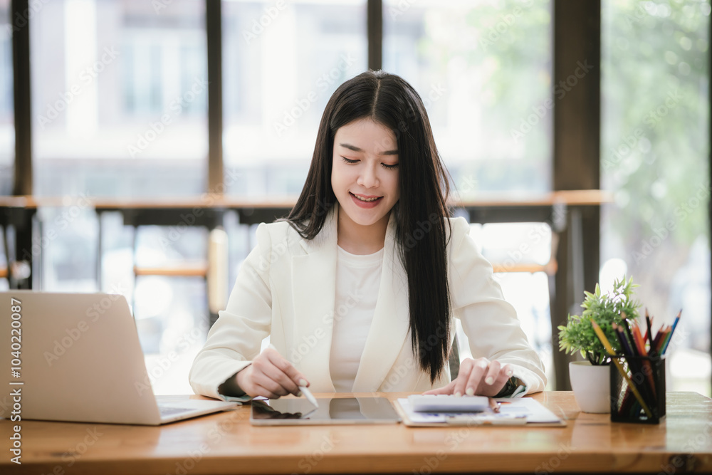 Beautiful Asian businesswoman focused on reviewing documents in a modern office. Beautiful Asian businesswoman focused on reviewing documents in a modern office.
