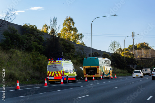 Traffic emergency patrol vehicle stopped beside broken down bus beside highway
