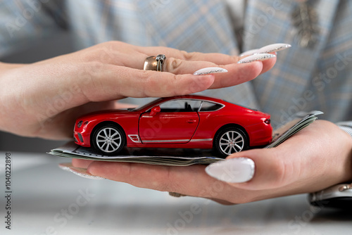 Insurance agent  holding red car toy as vechicle insurance photo