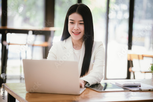 Portrait of a young businesswoman working on a laptop in an office