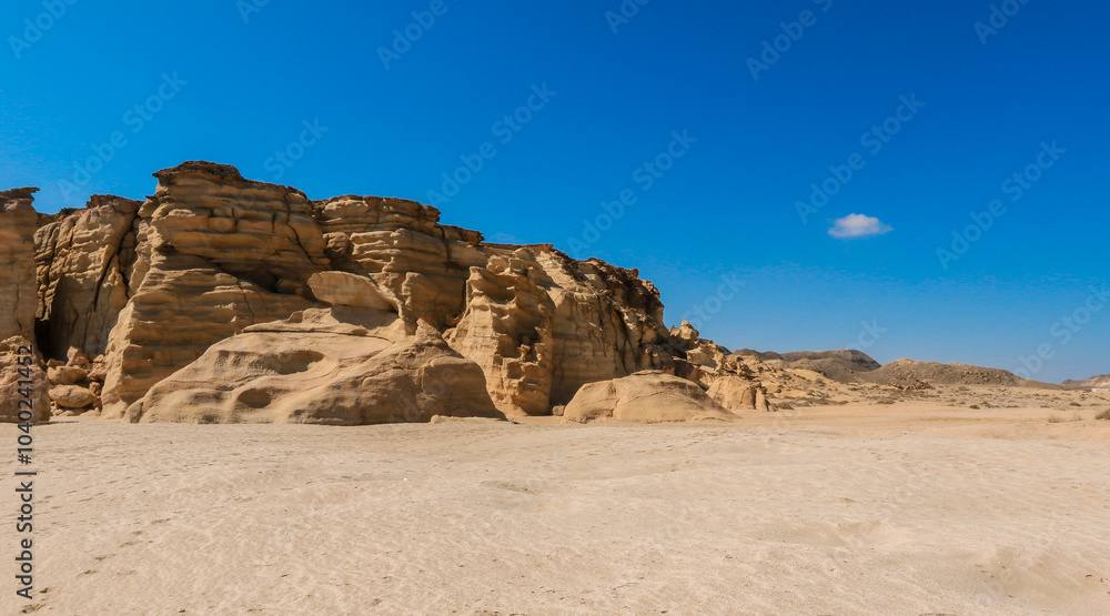Turtle Beach in Oman showing unique rock formations and sandy shores under a clear blue sky during daylight Turtle Beach in Oman showing unique rock formations and sandy shores under a clear blue sky during daylight