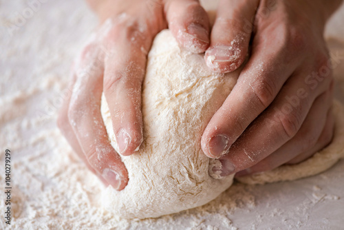 Close-up of baker making dough, person knead dough on table