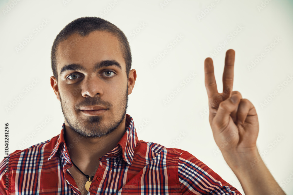 Young man pointing with two fingers on white background Young man pointing with two fingers on white background