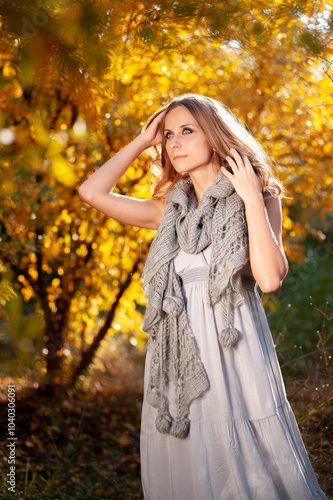 Outdoor portrait of young beautiful woman with long hair against autumn nature