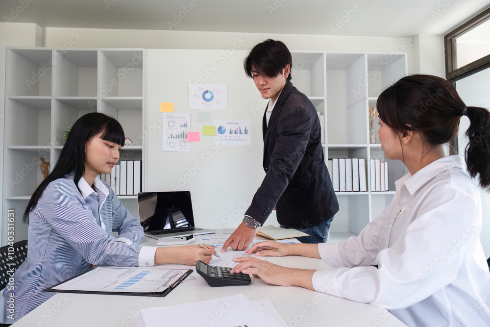 Young Business Team Collaborating on Marketing Strategy in Modern Office Setting with Charts and Graphs Young Business Team Collaborating on Marketing Strategy in Modern Office Setting with Charts and Graphs