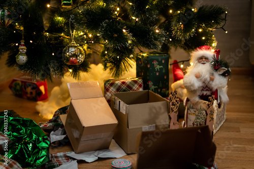 after Christmas . torn and damaged wrapping paper from gifts near the Christmas tree photo