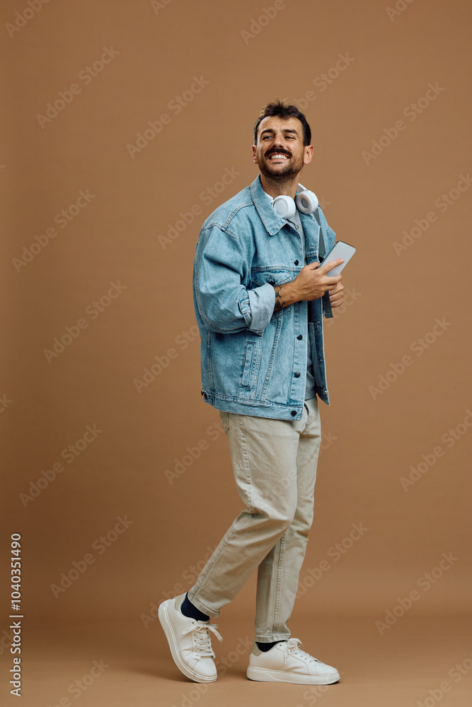 Happy man with mobile phone walking against neutral background and looking away. Happy man with mobile phone walking against neutral background and looking away.