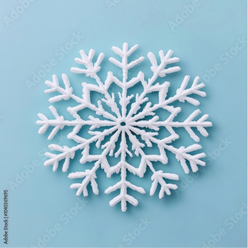 Intricate white snowflake on a soft blue background, perfect for winter designs.