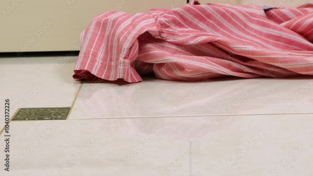 Colored men's shirts are thrown on the tiled floor. The theme of washing, sorting clothes and cleaning the house. Colored men's shirts are thrown on the tiled floor. The theme of washing, sorting clothes and cleaning the house.