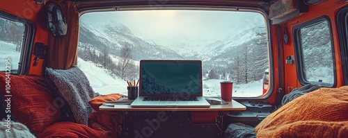 A workspace set up in a cozy camper van, with a laptop and a view of a snowy landscape photo