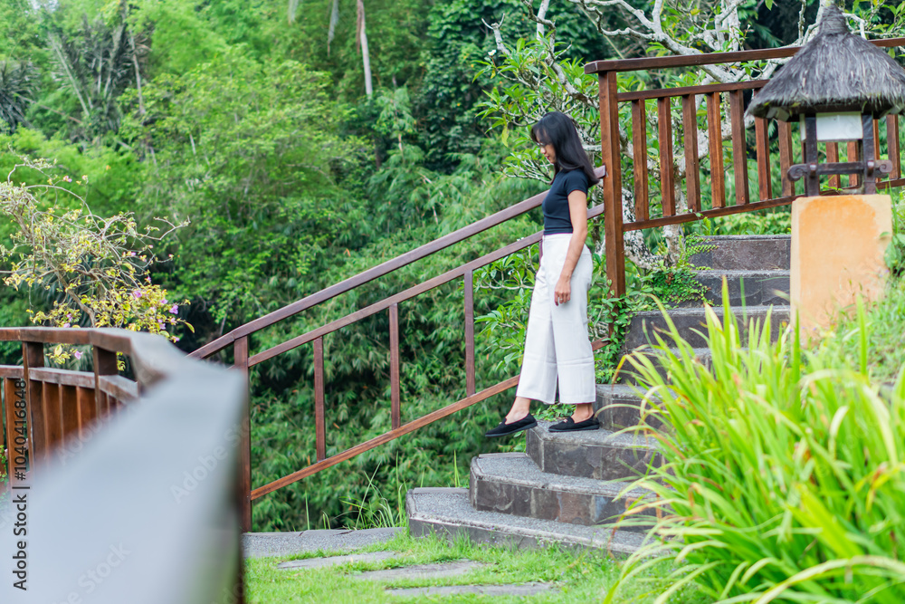 Fototapeta premium Woman Walking Up a Scenic Stone Staircase