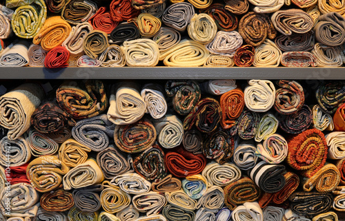 many rolls of various colored cotton yarn for sale on the shelf of a haberdashery specializing in supplies for hobbyists photo