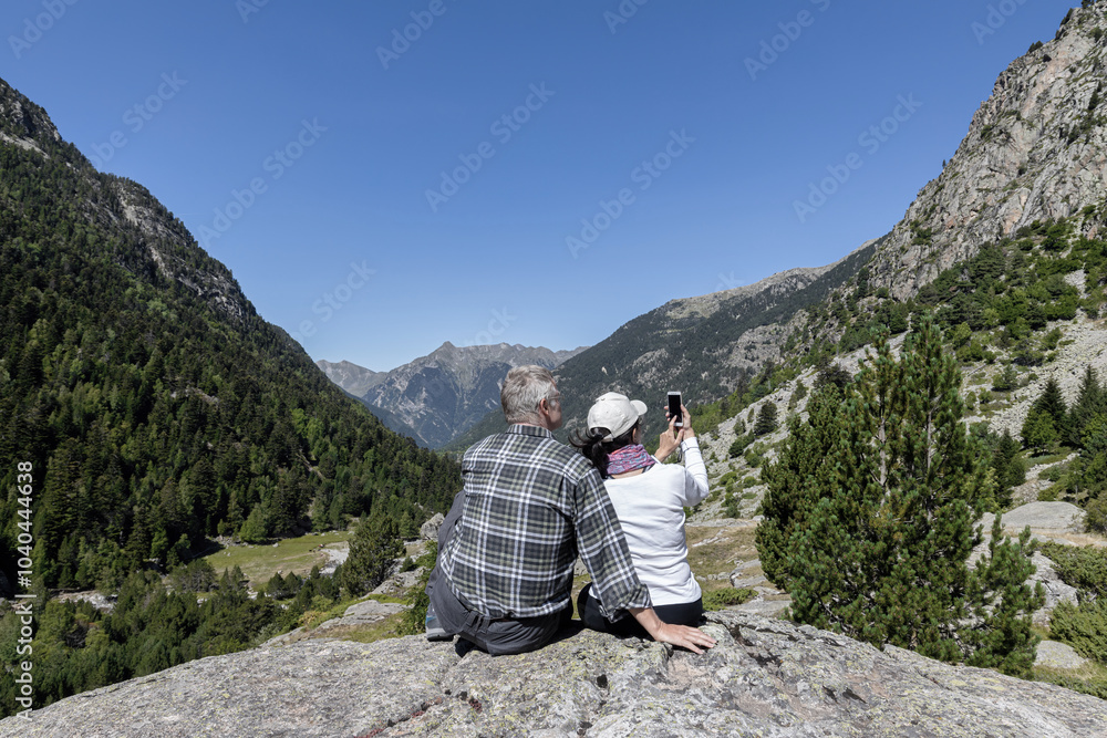 Tourist couple looking at the pike of mountain Pyrenees in Catalonia of Spain Tourist couple looking at the pike of mountain Pyrenees in Catalonia of Spain