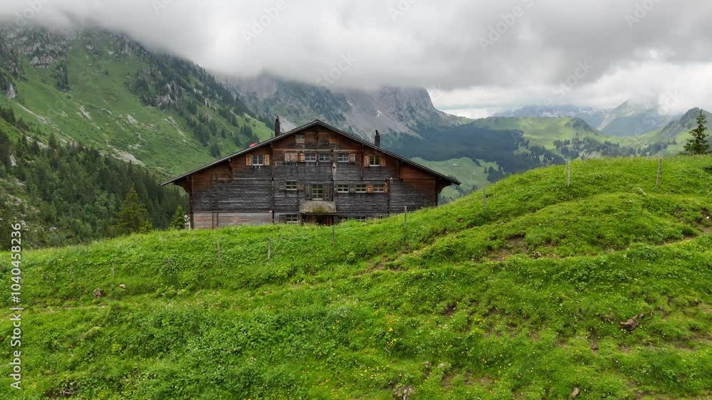 Drone flight above the Soldatenhaus mountain hut in Jaun Switzerland. Cloudy summer day. view on Swiss Alps, valley, Swiss mountain hut. aerail view. Drone flight above the Soldatenhaus mountain hut in Jaun Switzerland. Cloudy summer day. view on Swiss Alps, valley, Swiss mountain hut. aerail view.