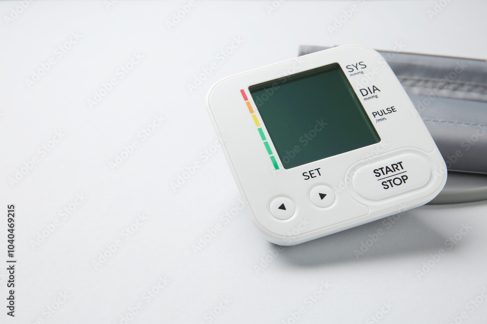 Blood pressure measuring device on light grey background, closeup. Space for text Blood pressure measuring device on light grey background, closeup. Space for text